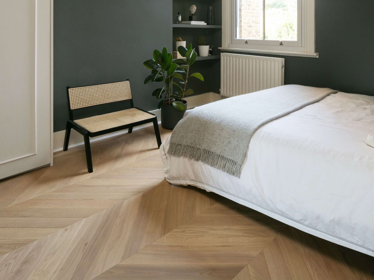Herringbone flooring in a bedroom with a green wall