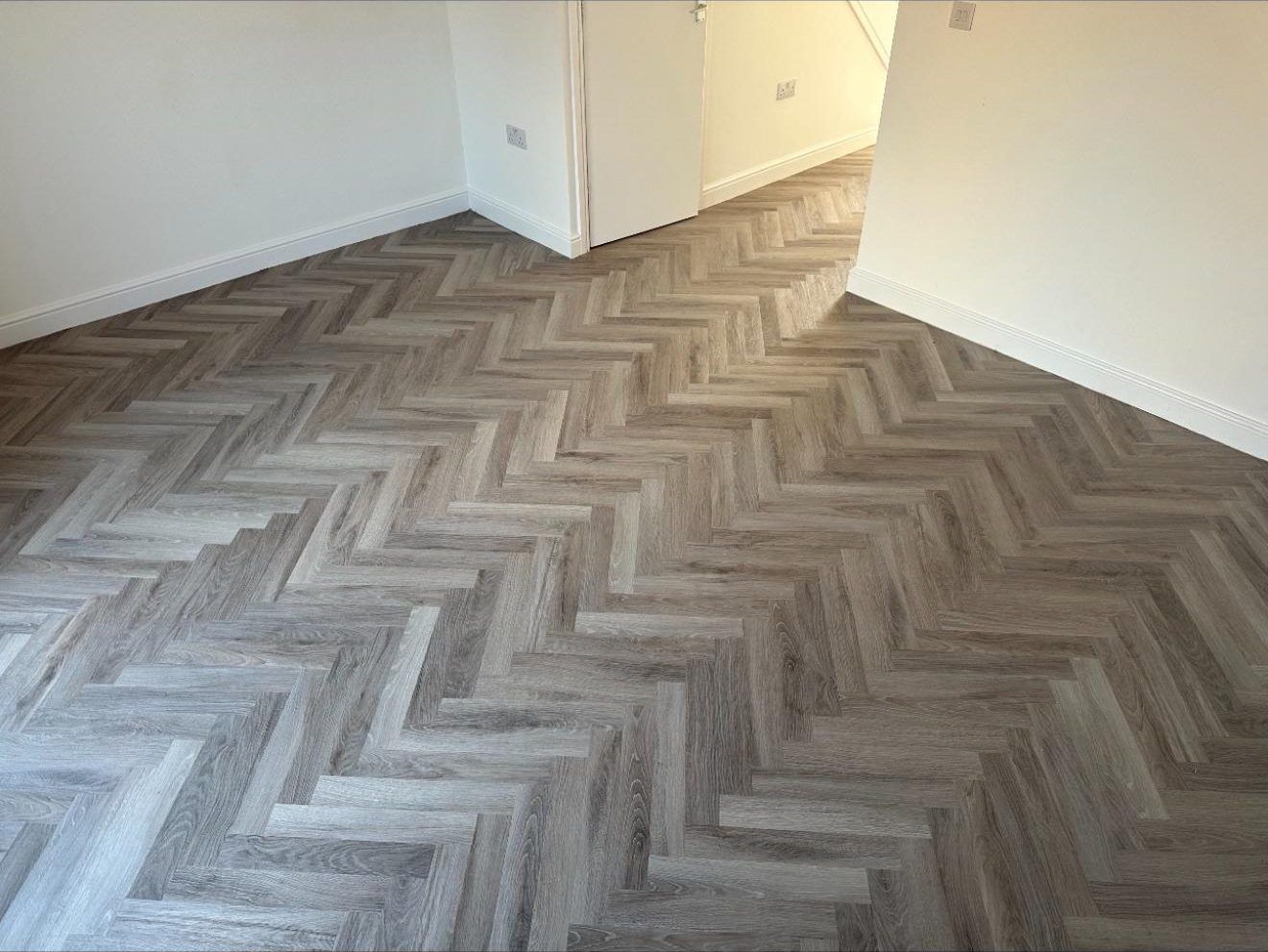 Dark herringbone flooring fitted in a living room