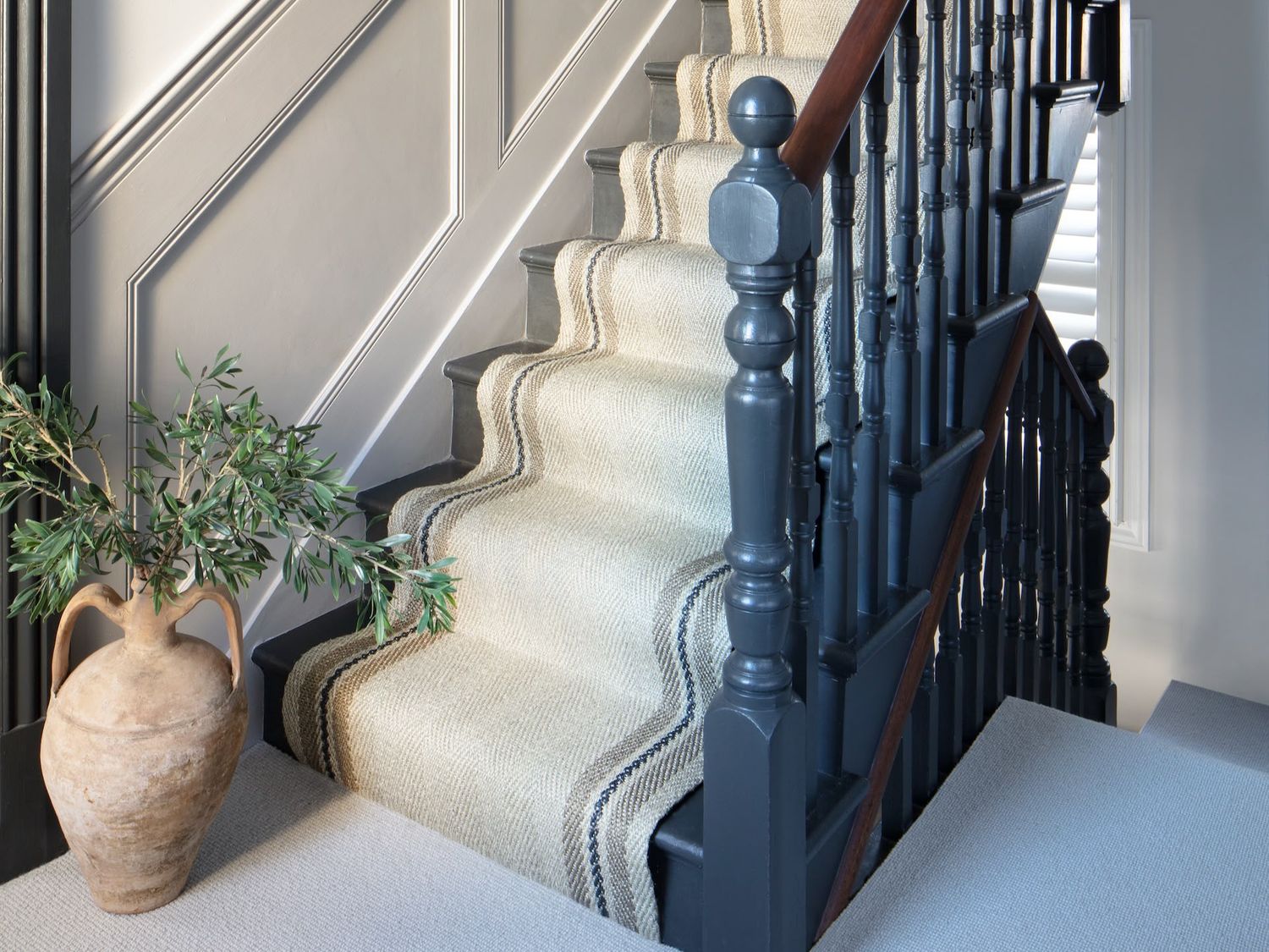 Cream stair runner on a dark painted staircase
